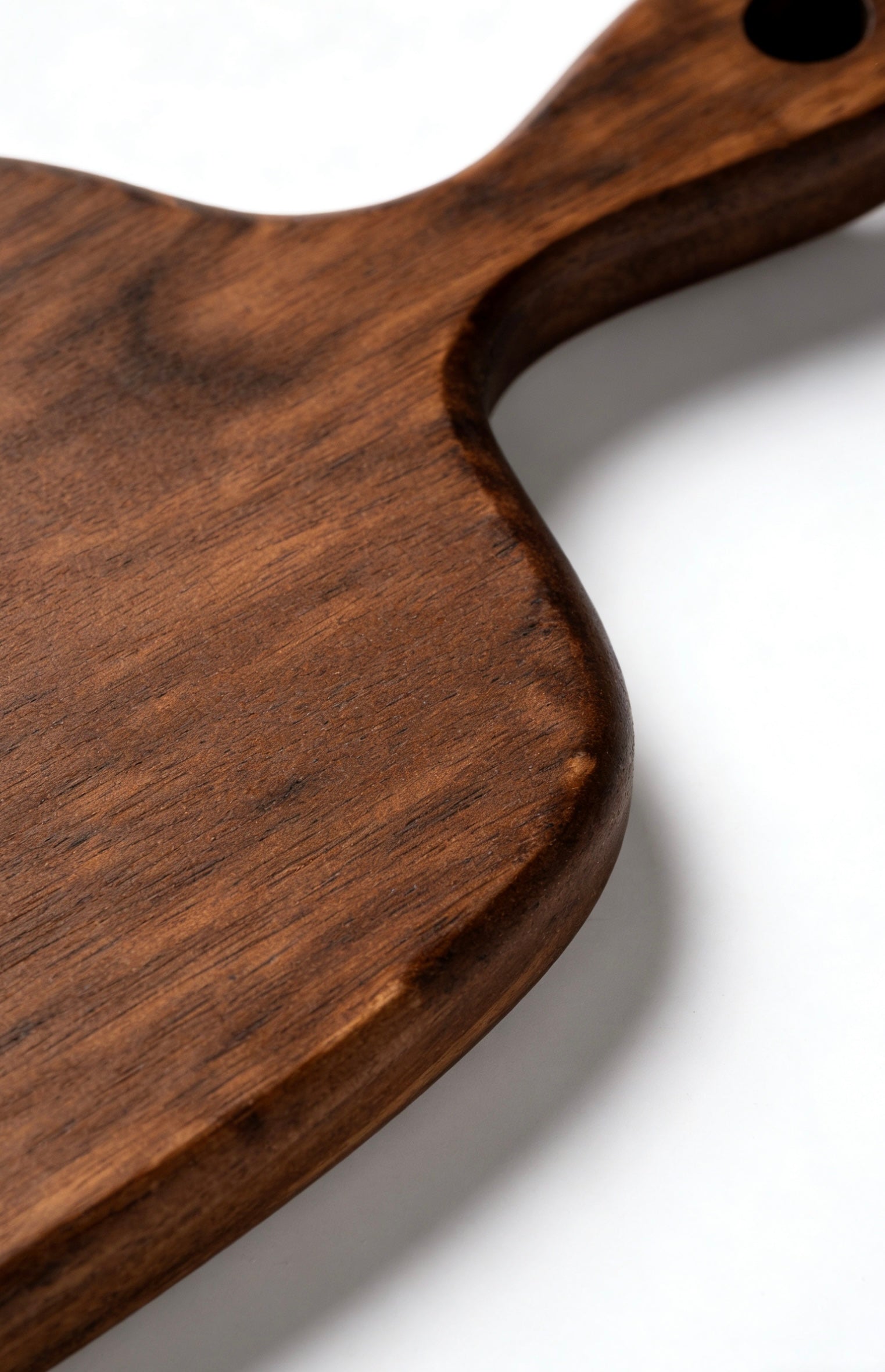 GrainGlow Hanging Cutting Boards in Black Walnut, Acacia, and Burmese Teak with integrated handle holes.