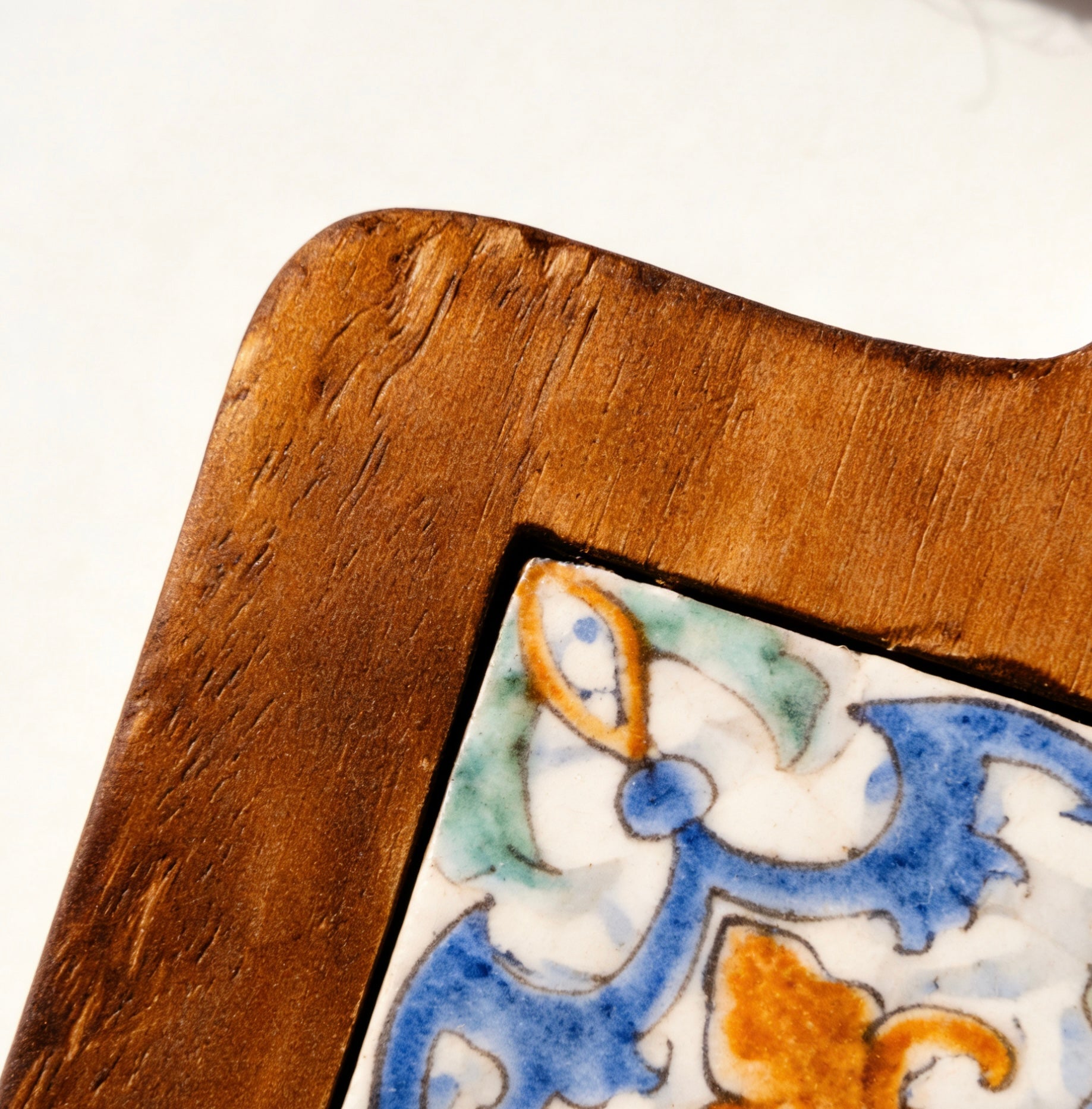 Close-up of the Azure Bloom floral tile pattern and glowing acacia wood texture