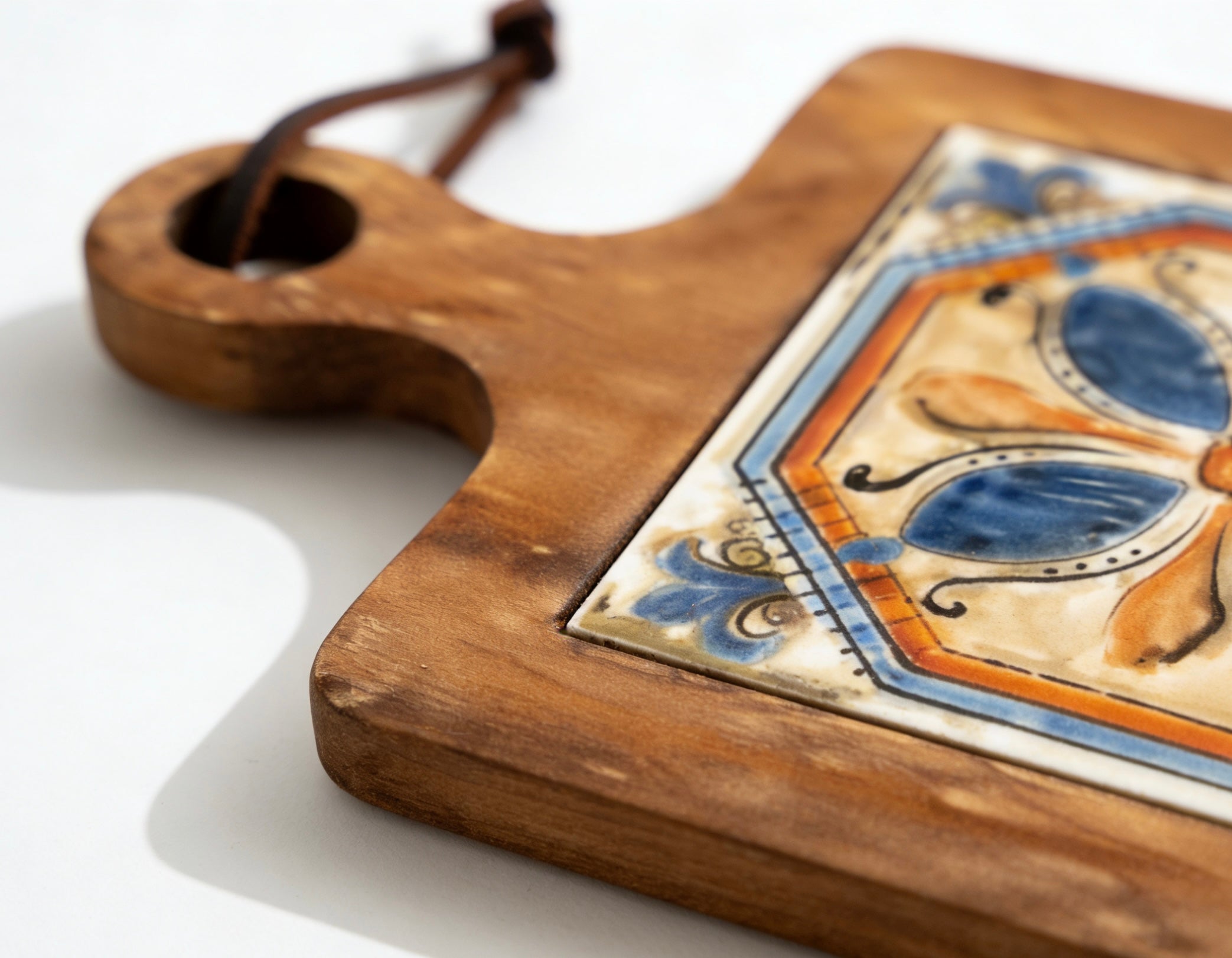 Acacia wood trivet with hanging loop used as Mediterranean style kitchen wall decor
