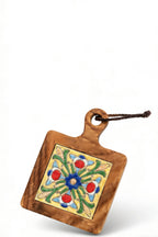 Close-up of the Vibrant Bloom floral ceramic tile and glowing natural acacia wood texture